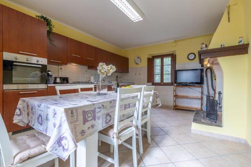 a kitchen with a table with chairs and a tv at Italian Experience- Villa La Pagliarina in Cartoceto
