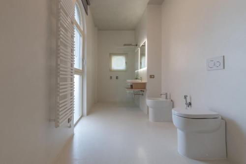 a white bathroom with a toilet and a sink at Italian Experience- Suite Marè in Porto Recanati