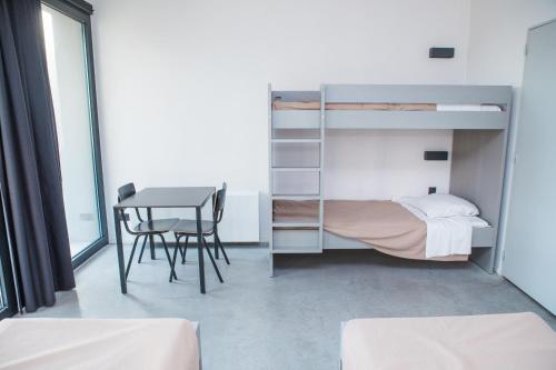 a bedroom with a bunk bed and a table at Antwerp Central Youth Hostel in Antwerp