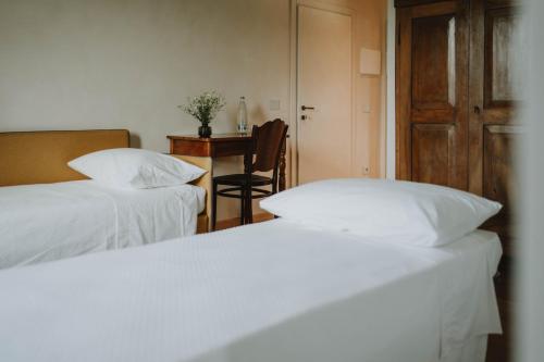 a bedroom with two beds and a desk with a chair at Corte Cavolo in Grezzana