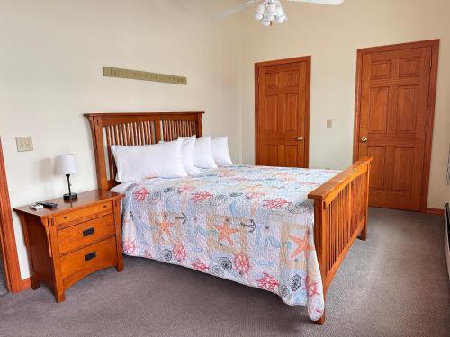 a bedroom with a wooden bed and a nightstand with a bed sidx sidx sidx at Abellona Inn & Suites in Old Orchard Beach