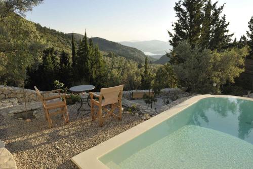 a swimming pool with two chairs and a table and a table and a tablektop at Mounty Island Villas in Lazaráta