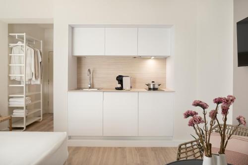 a kitchen with white cabinets and flowers in a vase at LAN Suites Antilla Playa in La Antilla