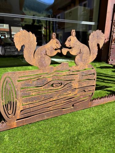 a statue of three squirrels kissing on a piece of wood at Hotel Roberta Alpine Adults only in Livigno