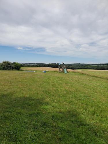 a large field with a playground in the middle of it at Cabane des bois in Rouffignac Saint-Cernin