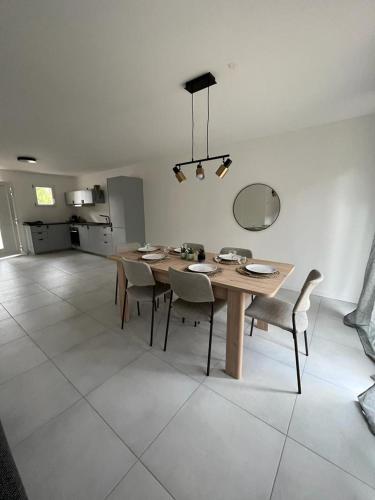 une salle à manger avec une table et des chaises en bois dans l'établissement Maison Chaleureuse 2, à Saint-Genis-Laval
