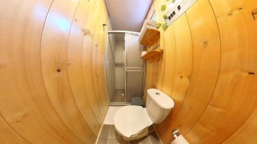 a small bathroom with a toilet and wooden walls at Refugio del Neusa in Cogua