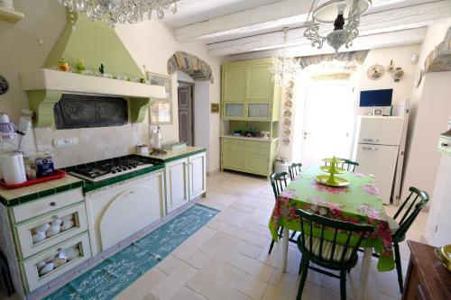 a kitchen with a table and a kitchen with green cabinets at La casa di sotto by PortofinoVacanze in Camogli