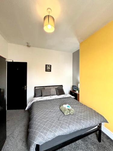 a bedroom with a bed and a yellow wall at CROFT House in Manchester