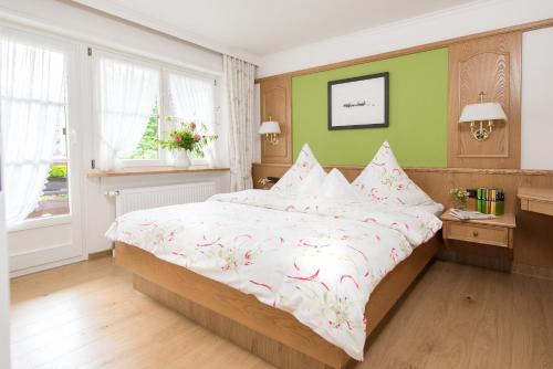 um quarto com uma cama grande com flores cor-de-rosa em Ferienhaus Kessler em Riezlern