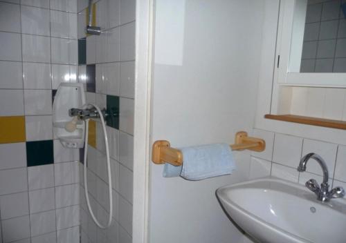 ein kleines Badezimmer mit Waschbecken und Dusche in der Unterkunft Village Vacances Le Lac Marin in Soustons