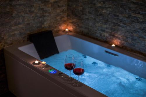 eine Badewanne mit zwei Gläsern Wein darin in der Unterkunft AQUAROOMS Luxury Suites in Palermo