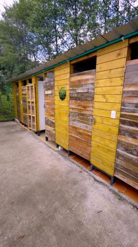 a row of wooden huts with their doors open at Refugio del Neusa in Cogua