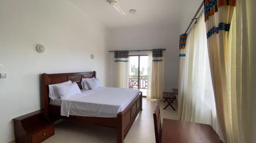 a bedroom with a bed and a window at Alfa Boutique Hotel in Kiwengwa