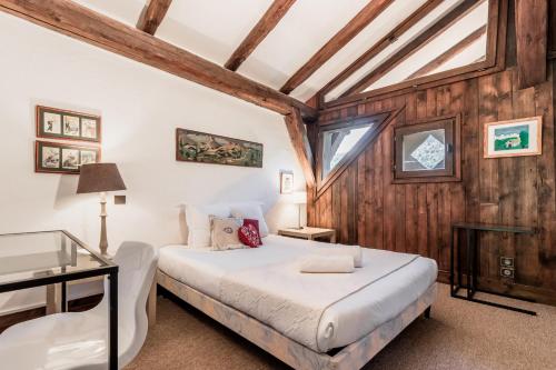 une chambre avec un lit dans une pièce aux murs en bois dans l'établissement La Poya haut - Calme - Vues magnifiques, aux Houches