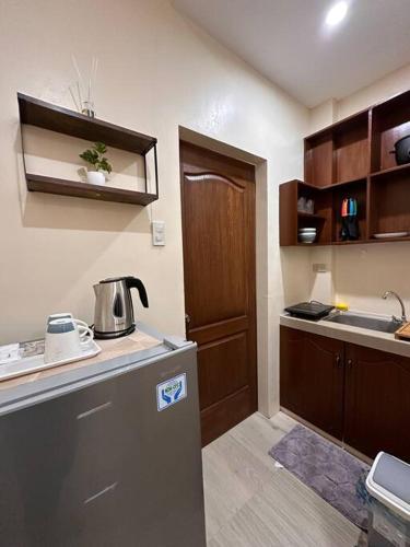 a small kitchen with a refrigerator and a sink at Modern 1-bedroom Apartment with Full-Bed in Sibulan