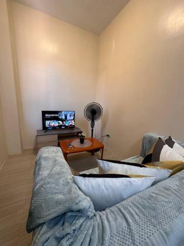 a living room with a couch and a table at Modern 1-bedroom Apartment with Full-Bed in Sibulan