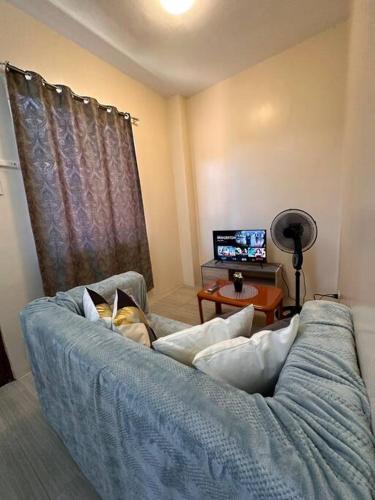 a dog laying on a couch in a living room at Modern 1-bedroom Apartment with Full-Bed in Sibulan