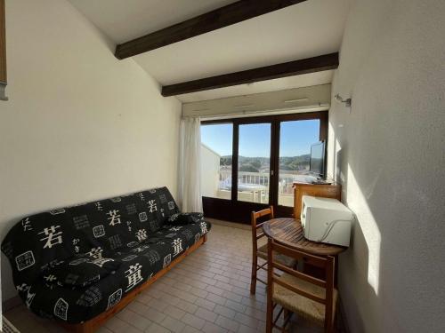 une chambre avec un canapé, une table et une fenêtre dans l'établissement Studio Port Soleil PS604 - 2 personnes accès Piscine, au Cap d'Agde
