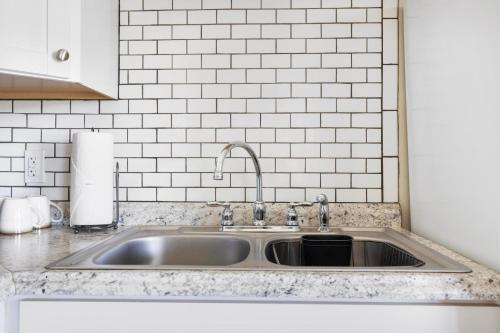 a kitchen counter with a sink and white tiles at 4BR House Minutes From BMS & Bristol Casino in Bristol