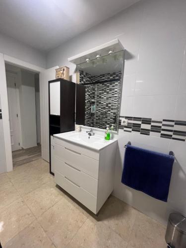 a bathroom with a white sink and a blue towel at Piso Los Jardines in Peñaranda de Bracamonte