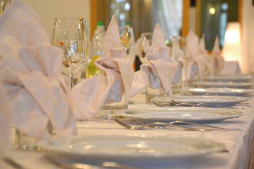 a table with white plates and glasses and napkins at Hotel Bracco in Loreggia