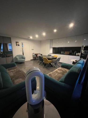 un salon avec un canapé et une table avec des chaises dans l'établissement Appartement Spacieux et Luxueux, à Franconville