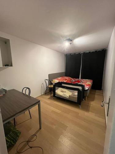 une pièce avec un lit et une table dedans dans l'établissement Appartement Spacieux et Luxueux, à Franconville