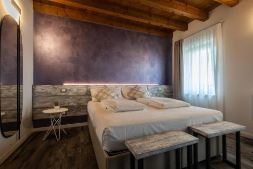 a bedroom with a large bed and a wall at Atmosfere Charme & Country in Udine