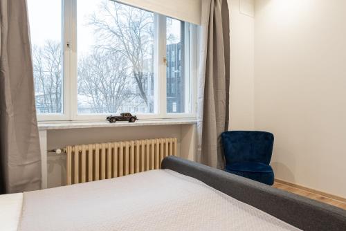 1 dormitorio con cama, ventana y silla azul en Yoga Residence Apartments, en Tallin