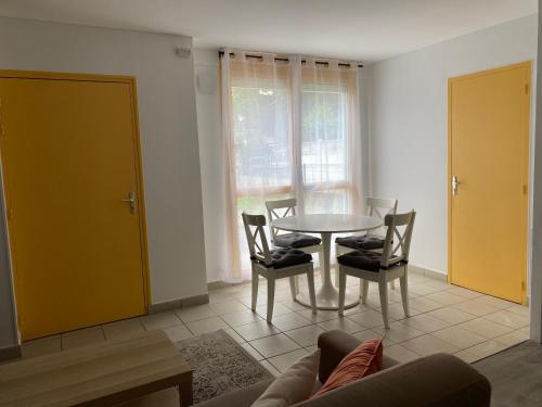 un salon avec une table, des chaises et un canapé dans l'établissement Maison Spacieuse et Confortable 100m2 avec Jardin, à Val de Reuil
