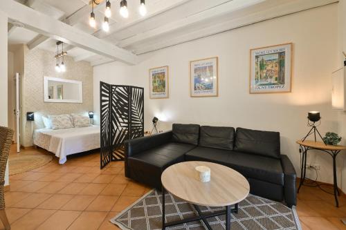 a living room with a black couch and a table at La ferme Saint-Antoine in Gassin