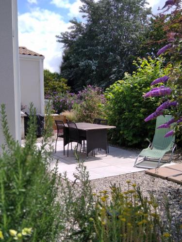 d'une terrasse avec une table et des chaises dans le jardin. dans l'établissement jolie maison à la campagne, à Rétaud
