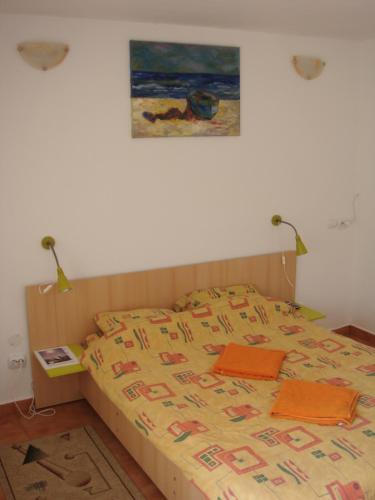 a bedroom with a bed and a painting on the wall at Casa de Vacanta Simfonia Apelor in Dunavăţu de Jos