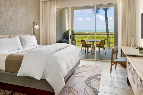 a bedroom with a bed and a balcony with a table at The Westin Hilton Head Island Resort & Spa in Hilton Head Island