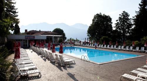 a swimming pool with lounge chairs and a resort at Selva Coccinella in Cissano