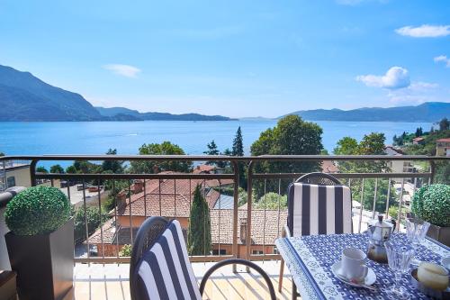 a table and chairs on a balcony with a view of the water at Selva Coccinella in Cissano