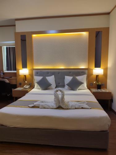 a hotel room with a bed with a pair of white shoes at York International Hotel in Dubai