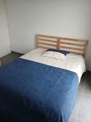 une chambre avec un lit avec une couverture bleue et blanche dans l'établissement Appartement Villeneuve les avignon, à Villeneuve-lès-Avignon