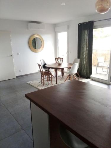 un salon avec une table et des chaises en bois dans l'établissement Appartement Villeneuve les avignon, à Villeneuve-lès-Avignon