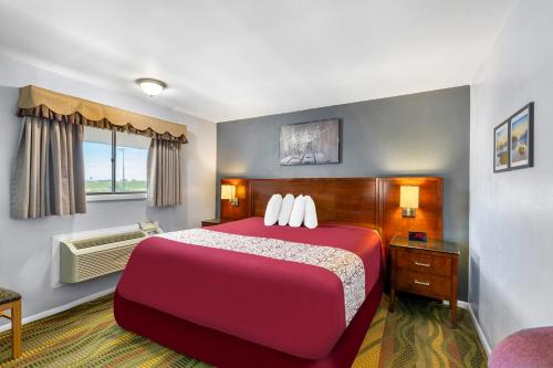 Una habitación de hotel con una cama roja y una ventana. en Americas Best Value Inn Belleville, en Belleville
