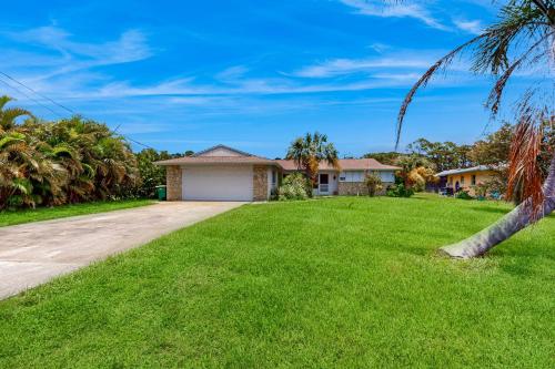 a house with a palm tree in front of a yard at Mangrove View on Oyster Creek in Englewood