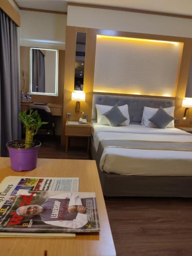 a hotel room with a bed and a magazine on a table at York International Hotel in Dubai