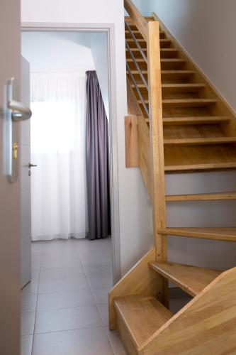 a wooden staircase in a room with a window at Résidence Coté Mer in La Grande-Motte