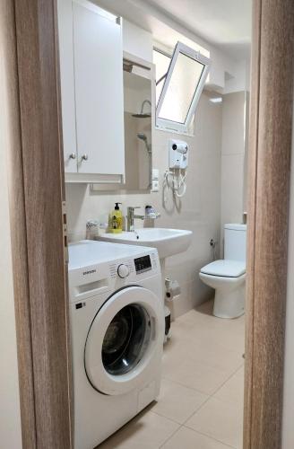 un bagno con lavatrice e lavandino di Villa 29 a Sarandë