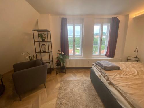 a bedroom with a bed and a chair and a window at Apartmán v centru Krumlova in Český Krumlov