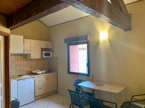 - une cuisine avec une table, une petite table et des chaises dans l'établissement Escale à Aubenas, à Aubenas