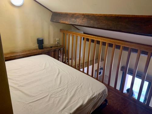 Ce lit se trouve dans un dortoir doté d'une balustrade en bois. dans l'établissement Escale à Aubenas, à Aubenas