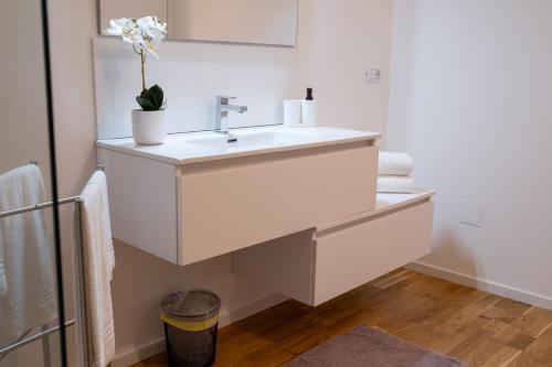 a white bathroom with a sink and a mirror at FP Apartments Pizzo in Pizzo