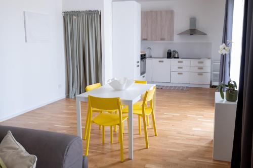 a white table with yellow chairs in a kitchen at FP Apartments Pizzo in Pizzo